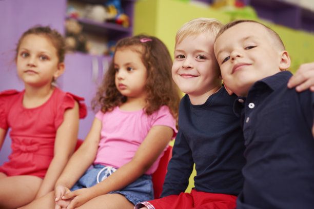 两个微笑的男孩在幼儿园拥抱的肖像图片下载