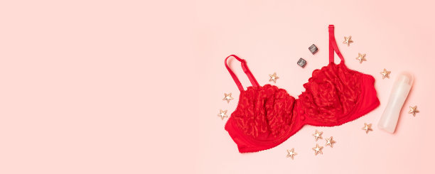浪漫爱情的概念。红色女性内衣与性润滑剂，方块和星星在粉红色的背景。图片下载