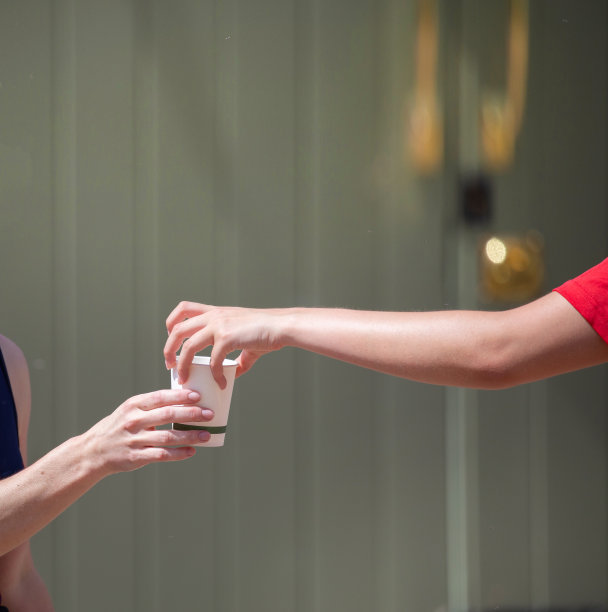 志愿者在饮料站给铁人三项选手递上一杯清爽的水图片下载