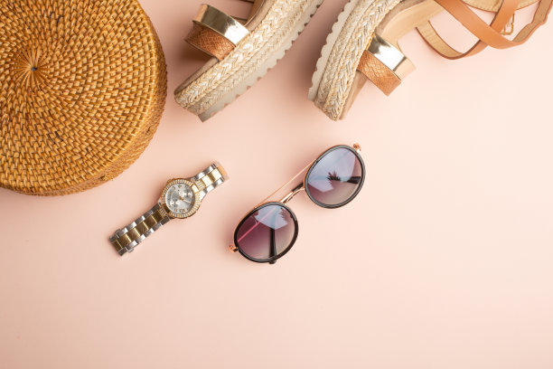 以柳条为背景的夏季时尚包，以及女士的夏季鞋，以及太阳镜、手表。夏日时尚，假日概念。飞。横幅、水平的照片图片下载