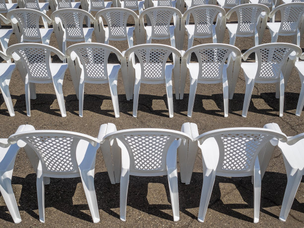 许多白色的椅子排成一排。没有人的塑料椅子。活动准备工作图片下载