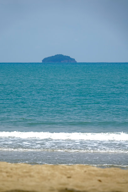 沙滩椅上白色的沙滩上有海浪和阳光。在海滩上放松。图片下载