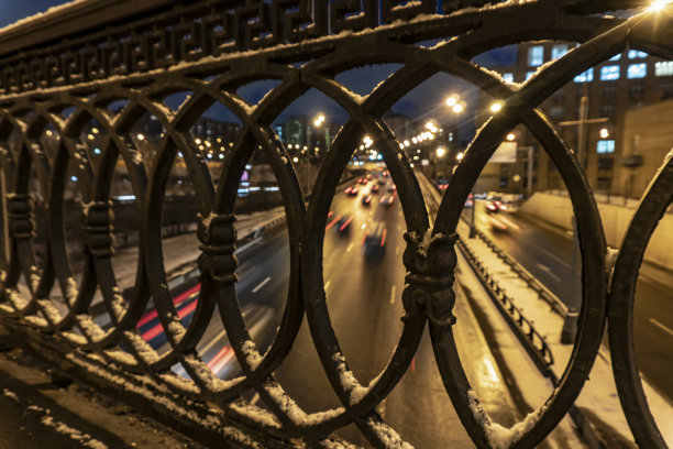 这是夜间车辆穿过铸铁围栏的照片图片下载