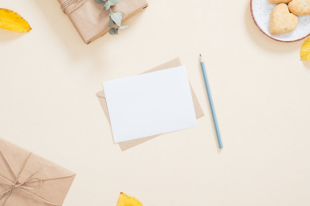 秋天的成分。舒适女性的桌面与信，空白的纸卡，礼盒，饼干，落叶在柔和的米色背景。平躺，俯视图，头顶。秋天,秋天的概念。图片下载