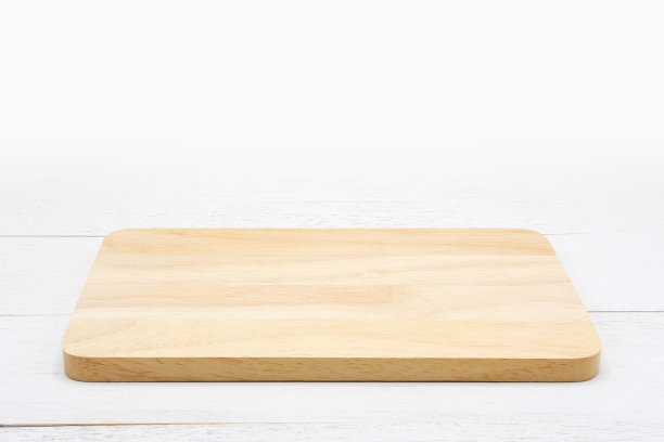 白色木桌上放着空的长方形木砧板。图片下载