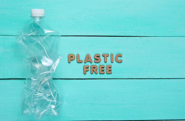 塑料自由概念。皱巴巴的瓶子在蓝色木制背景与文本塑料免费图片下载