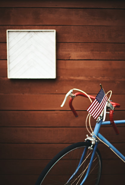 木制围栏前插着美国国旗的彩色赛车图片下载