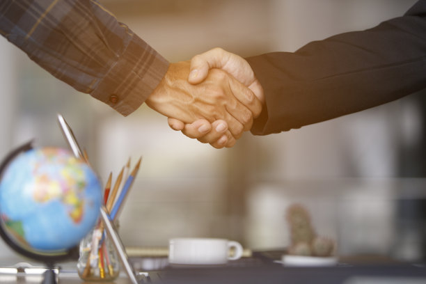 两个商务人士在办公室开会时握手的特写，图片下载