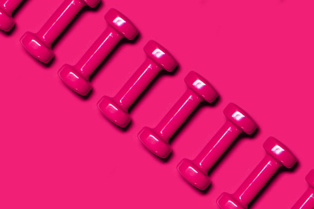 粉红色背景上的一排粉色哑铃。卫生保健的概念。图片下载