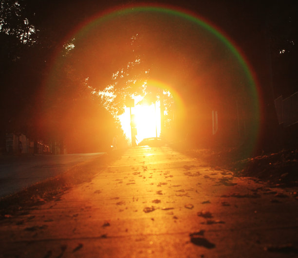 夕阳西下时，人行道上闪烁着耀眼的光和光晕图片下载