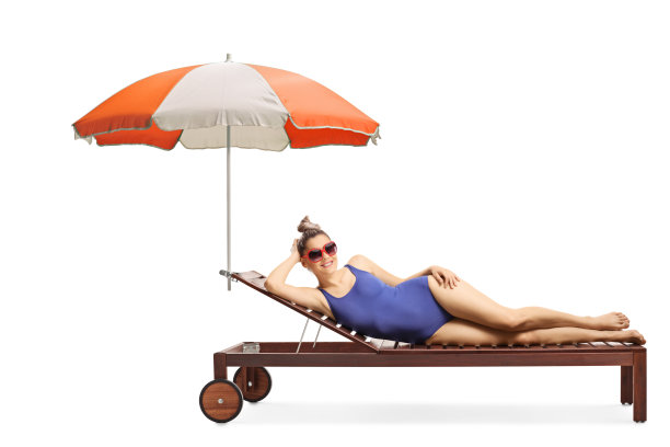 年轻迷人的女人躺在日光浴床上图片下载