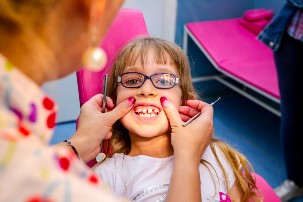 戴眼镜的可爱小女孩的肖像，在牙医诊所的孩子图片下载