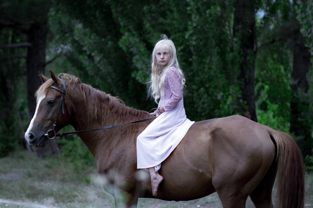 穿着时髦的女孩骑着棕色的马。美丽的白人女孩，一头金色长发，穿着粉红色的裙子，骑着一匹棕色的马在森林里。自然美景的概念。时尚插画。自然背景图片下载