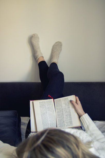 女孩躺在床上看书图片下载
