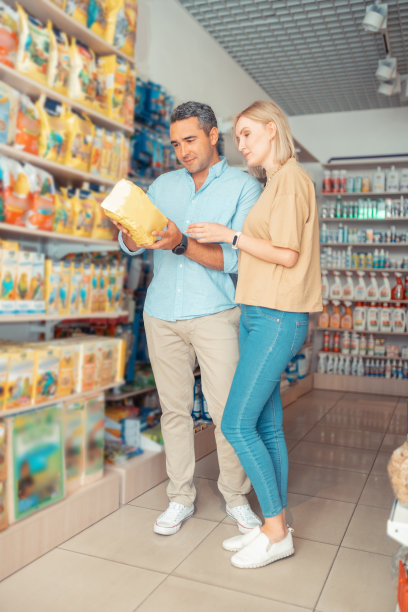 妻子穿着牛仔裤站在丈夫旁边给狗喂食图片下载