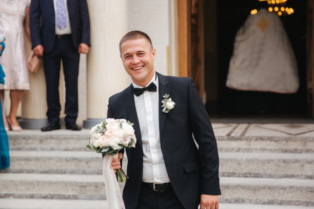 快乐的新郎在教堂边等待新娘。等待第一眼图片下载