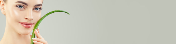 用芦荟拉近女性的脸。美丽的模型与健康清晰的皮肤和芦荟叶横幅背景图片下载