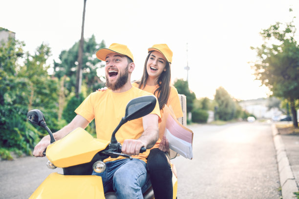 兴奋的送货同事享受新的公司摩托车图片下载