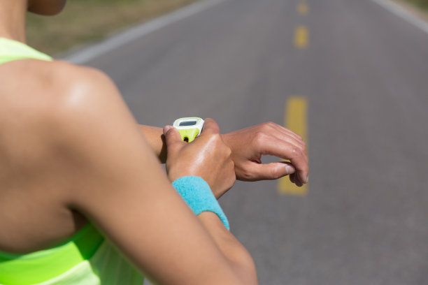 年轻女子跑步准备跑set和看运动智能手表图片下载