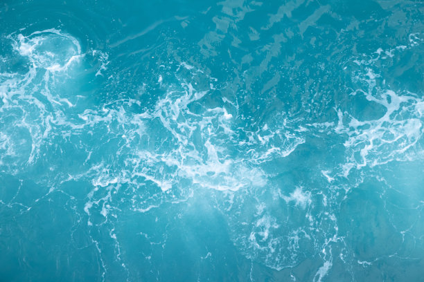 海浪在海浪中溅起波纹水。水蓝色背景。图片下载