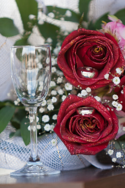 桌上放着花和戒指的空香槟杯图片下载