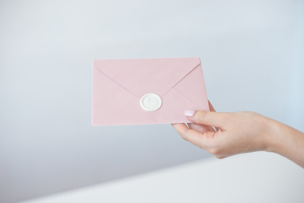 女性手握邀请信封的特写照片蜡印章，礼品证书，明信片，婚礼邀请卡图片下载