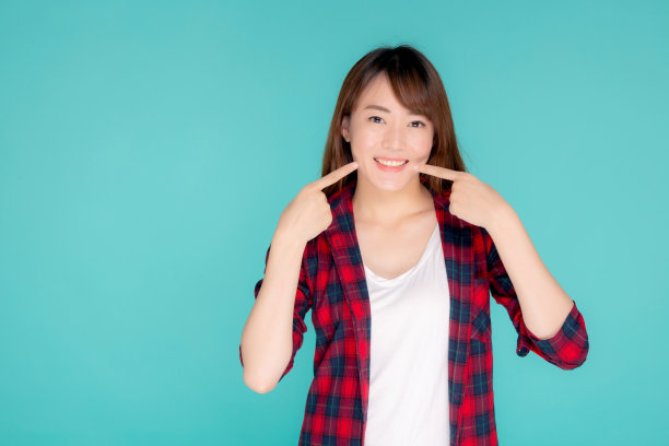 美丽的肖像年轻的亚洲女人微笑自信和兴奋的暑假孤立的蓝色背景，美丽的亚洲女孩享受和愉快的指指点点的脸颊旅行，旅游概念。图片下载