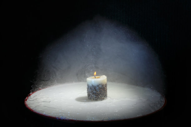 黑色背景上燃烧着的蜡烛在一团烟雾中燃烧。漂亮的智能手机壁纸原始图片图片下载