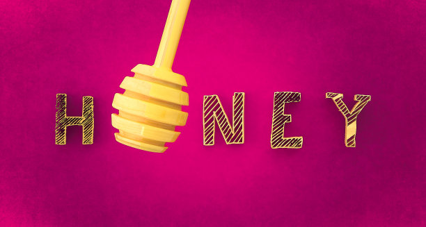 有机蜂蜜与木制勺在粉红色的背景与复制空间图片下载