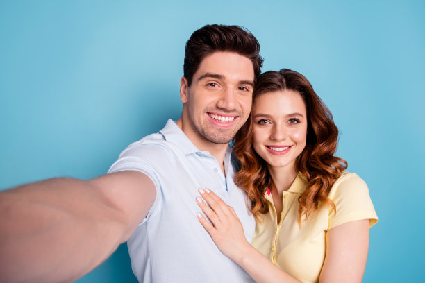 近距离的照片狐狸女士深色的男人对自拍浪漫的约会情人节穿休闲t恤孤立的蓝色背景图片下载