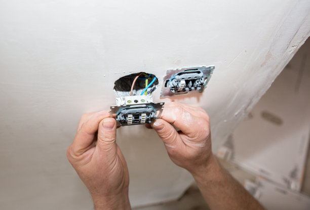人类正在墙上制造插座开关。公寓的维修保养工作。在室内装修。图片下载