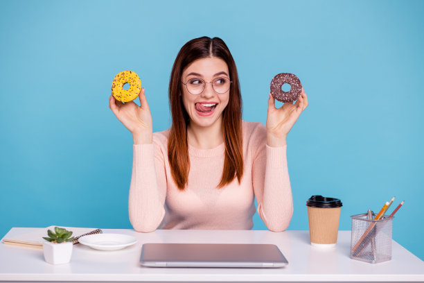 近距离的照片美丽的她，她的狐狸女士手手臂面包房，甜甜甜圈，撒糖舔嘴唇日记，花瓶，铅笔盒，桌子，桌子，戴眼镜，柔和的套衫，孤立的亮蓝色背景图片下载