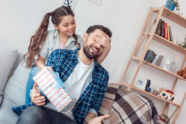 爸爸和小女儿在家里坐着，小女孩惊喜地把礼物送给爸爸玩图片下载
