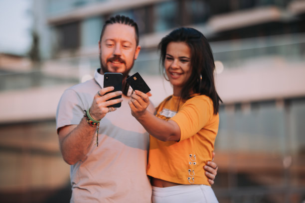 这对幸福的情侣用信用卡和智能手机在线支付街头库存照片图片下载