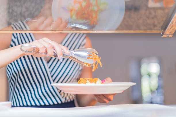 彩色照片上的铁钳在白色盘子上切好的胡萝卜-素食图片下载
