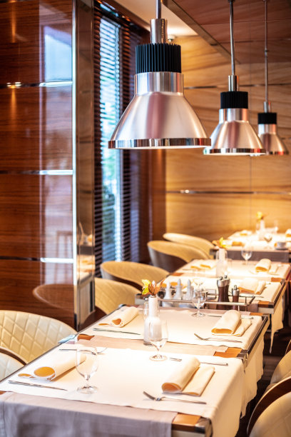 高级餐厅里一排上面有灯的桌子和座位图片下载