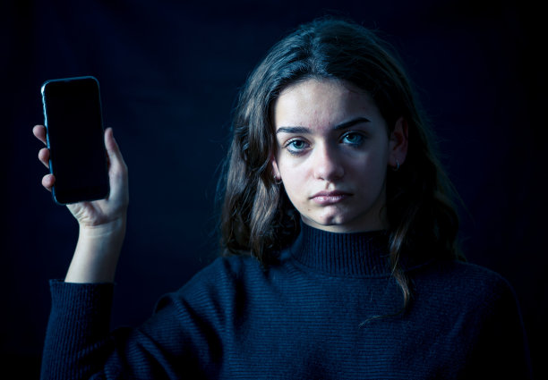 害怕不安的女孩欺负网上遭受骚扰，哭泣，感到绝望和恐吓。网络欺凌、跟踪者、社交媒体和互联网危险的儿童受害者。戏剧性的暗光。图片下载