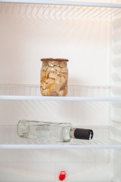 冰箱的架子上放着蘑菇和瓶装伏特加图片下载