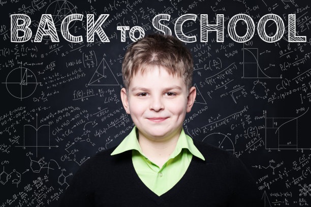 年轻的学生在黑板上微笑。返回学校背景图片下载