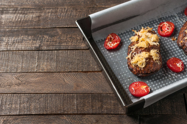 烤茄子，芝士和番茄片在方形金属火锅在棕色的木桌上图片下载