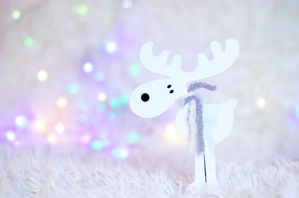 装饰圣诞驯鹿与模糊发光的灯光背景。圣诞装饰品图片下载