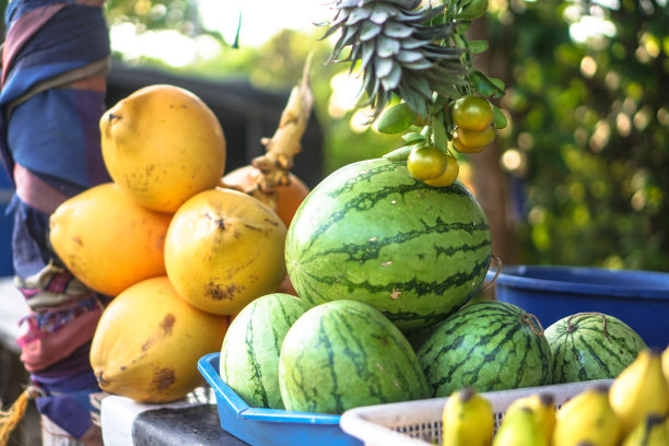 西瓜和甜瓜在亚洲市场上出售。户外售卖素食水果。股票的照片图片下载
