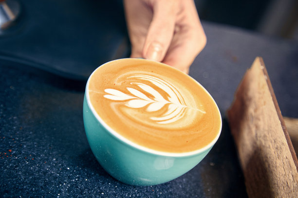 咖啡馆里的咖啡师。在柜台后面给顾客拿铁或卡布奇诺的女士。餐厅咖啡店概念。健美的图片。副本的空间。新鲜的煮了咖啡图片下载