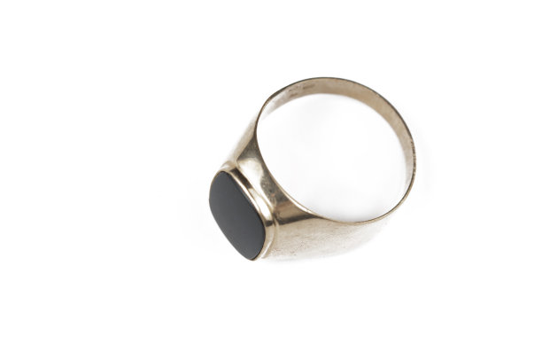 男性金戒指与黑色的石头孤立在一个白色的背景。图片下载