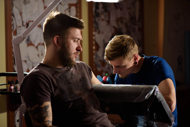 近距离纹身机。人们在沙龙用它创作手头的图片图片下载