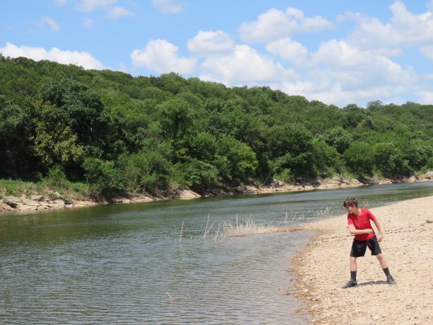 一名少年在德克萨斯州的布拉索斯河上跳石头图片下载