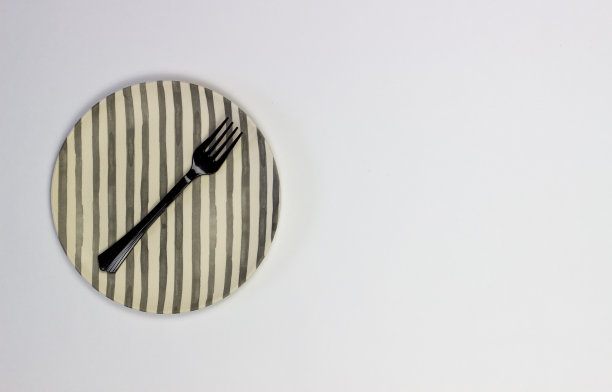 白色背景上的盘子和叉子。极简主义。图片下载