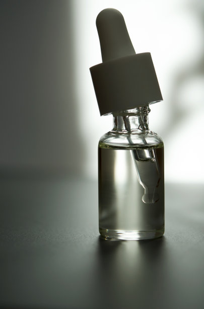 化妆或医疗用的带吸管的玻璃瓶。皮肤护理的概念。自然光硬，阴影深。——图片图片下载