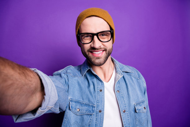 酷家伙的照片在线视频翻译自己的博客穿着眼镜休闲牛仔装孤立的紫罗兰背景图片下载