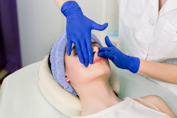 年轻美丽的女孩有脸部按摩放松在水疗沙龙。一个女人躺在按摩台上的照片图片下载